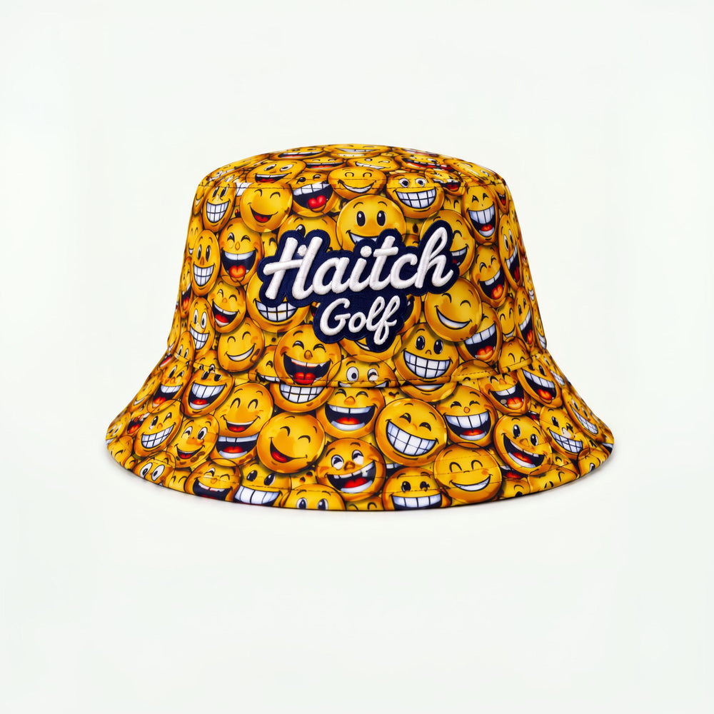 A yellow bucket hat featuring an all-over pattern of smiling emoji faces and the text 'Haitch Golf' in white script with a dark blue outline, set against a plain white background.
